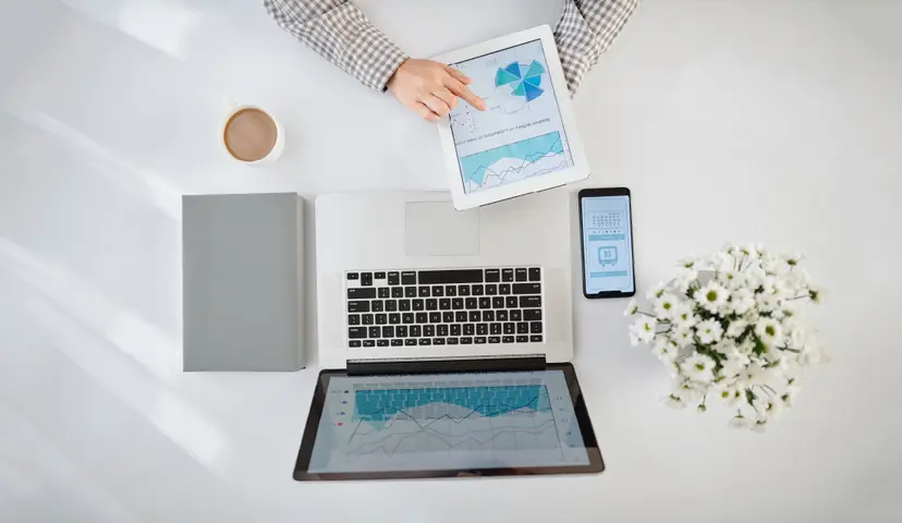 Aerial view of desk with laptop, ipad, iphone and notebook