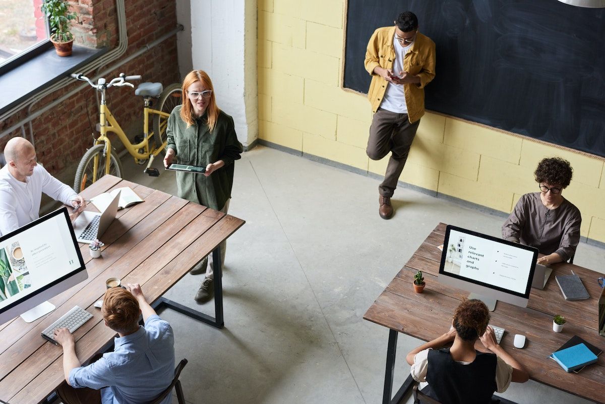 Aerial view of open modern office with people working at desks 
