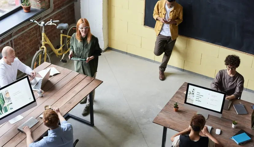 Aerial view of open modern office with people working at desks 